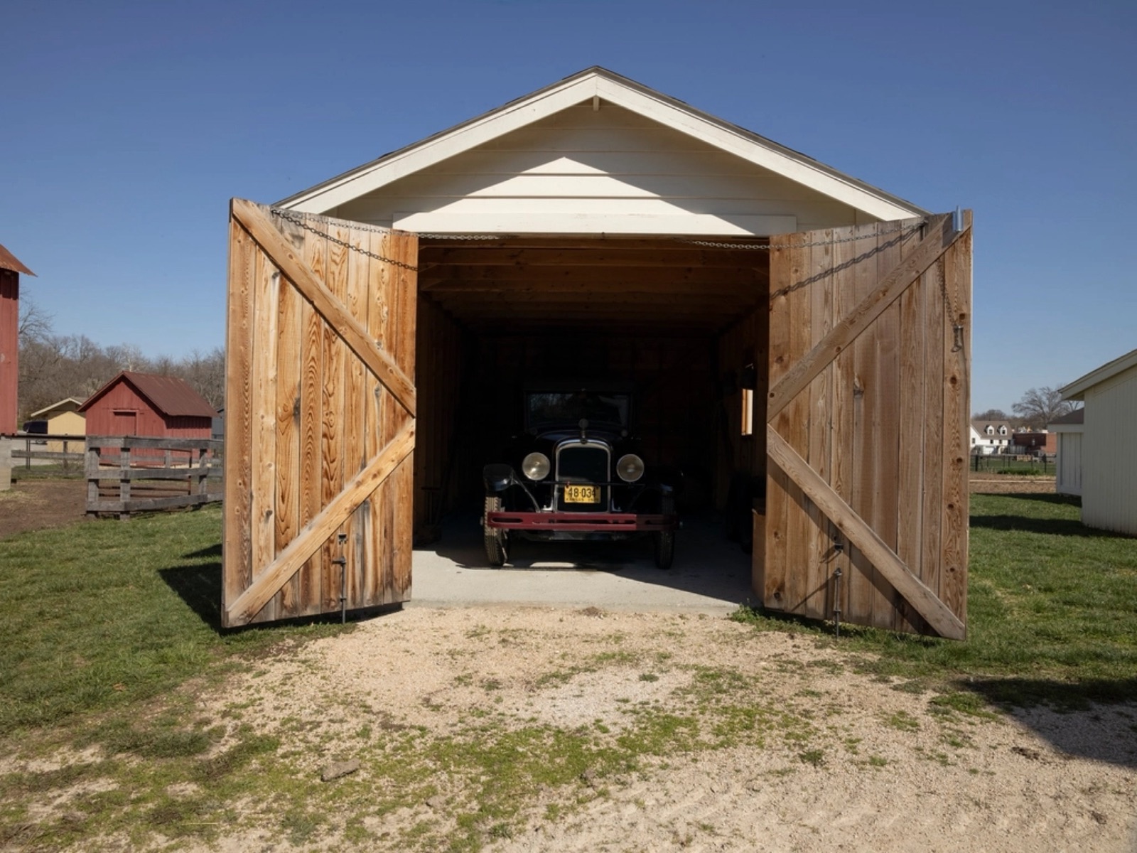 Detached wood garage with its barn doors open