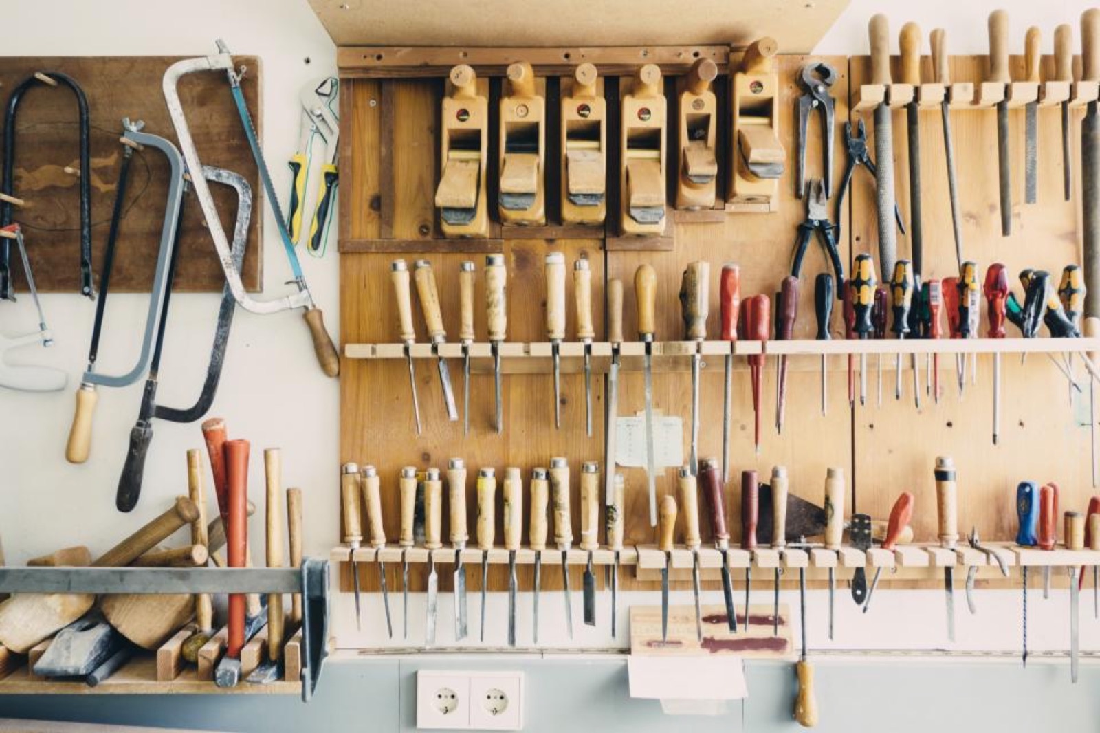 Hand tools hanging on a pegboard wall in a workshop
