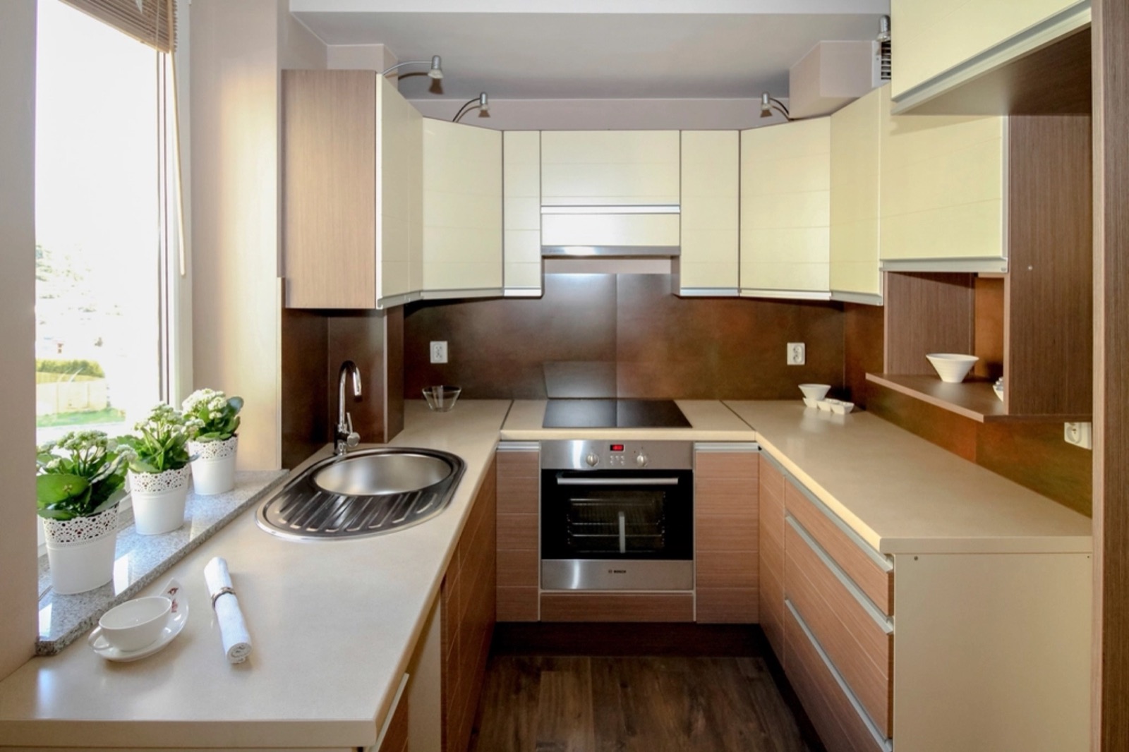 Finished modern kitchen with light cabinets and wood floors