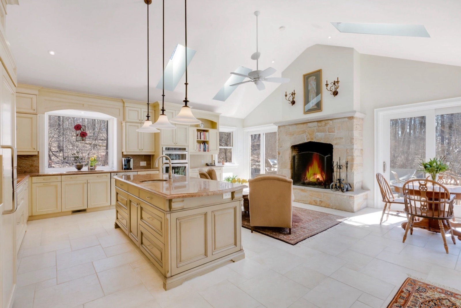 Open kitchen with an island next to a living area with a fireplace