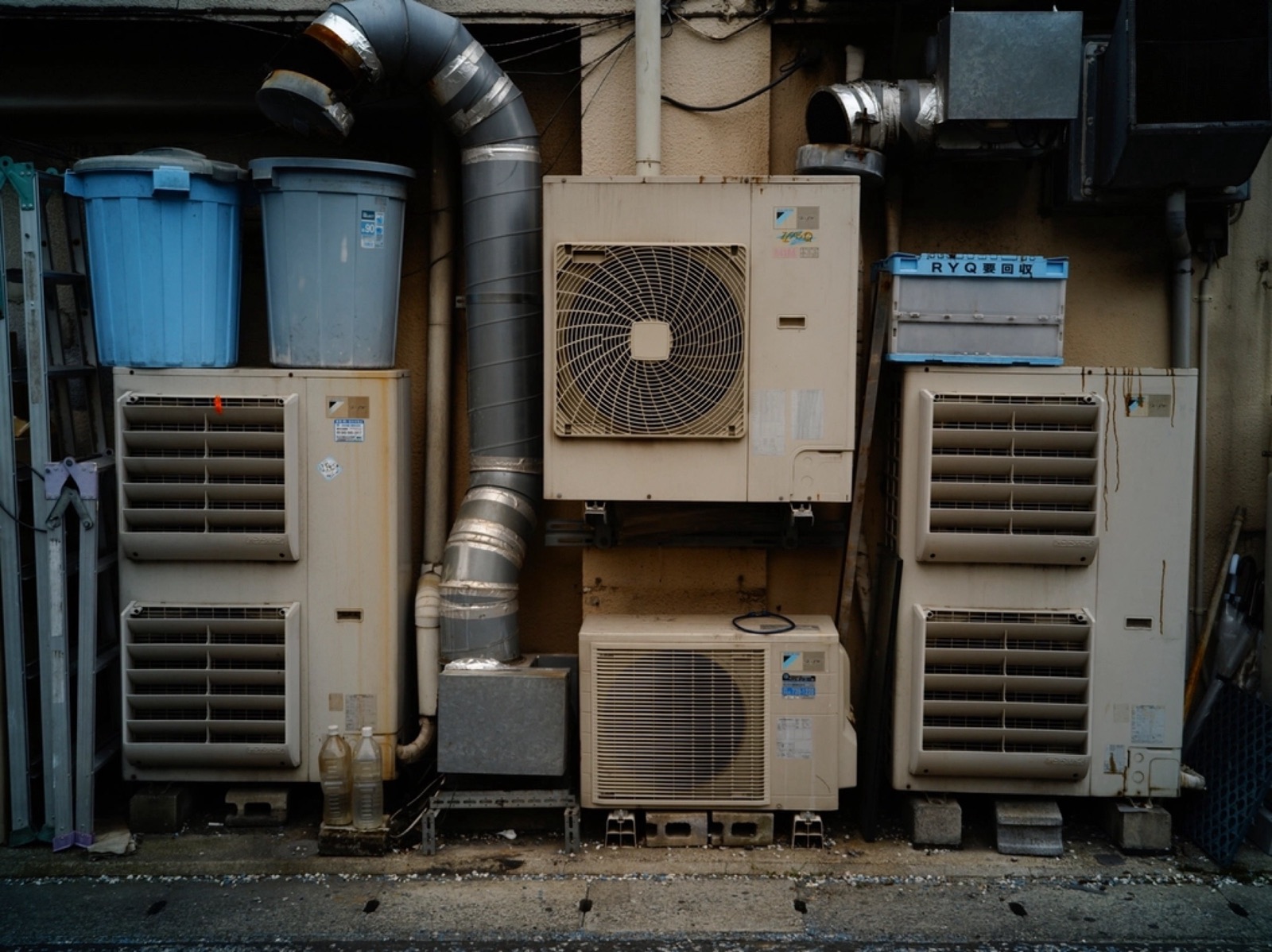 Outdoor air conditioner and heat pump units mounted along a building wall